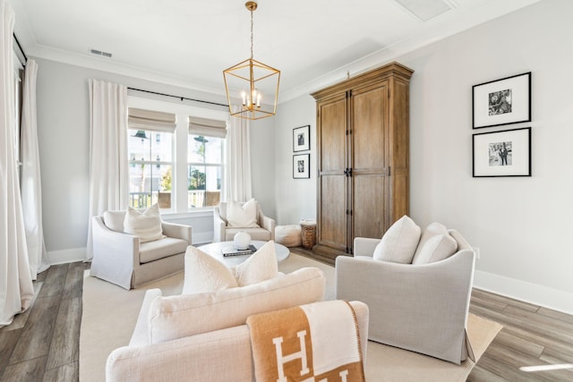 living room with crown molding, wood-type flooring, and a chandelier