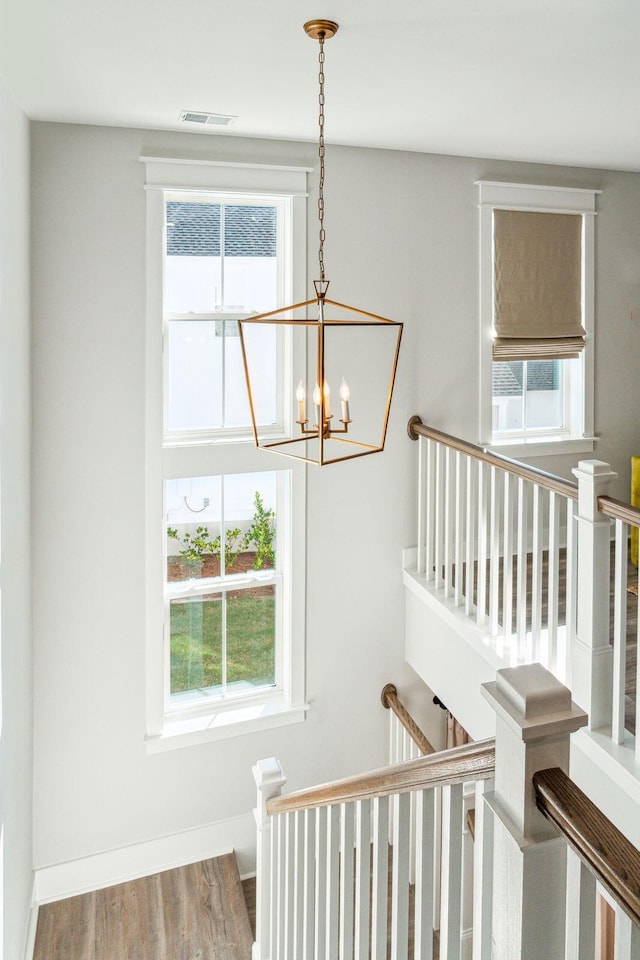 staircase featuring a notable chandelier and hardwood / wood-style flooring