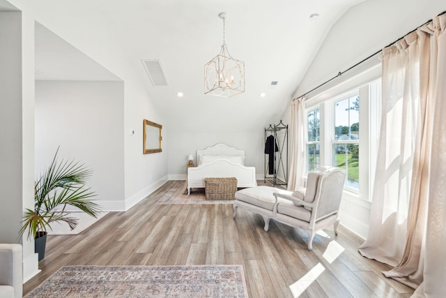 bedroom featuring a chandelier, vaulted ceiling, and light hardwood / wood-style floors