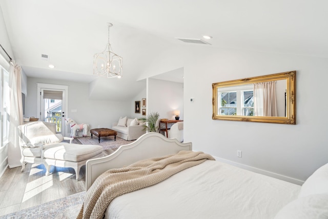 bedroom with light hardwood / wood-style floors, lofted ceiling, and a chandelier