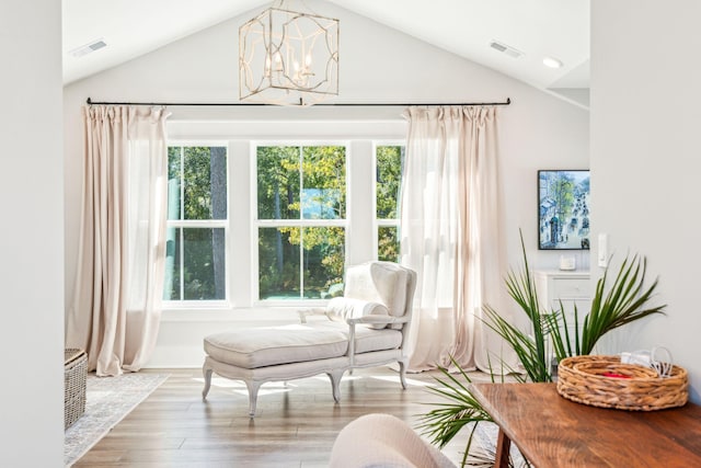 sitting room with high vaulted ceiling, a chandelier, and light wood-type flooring