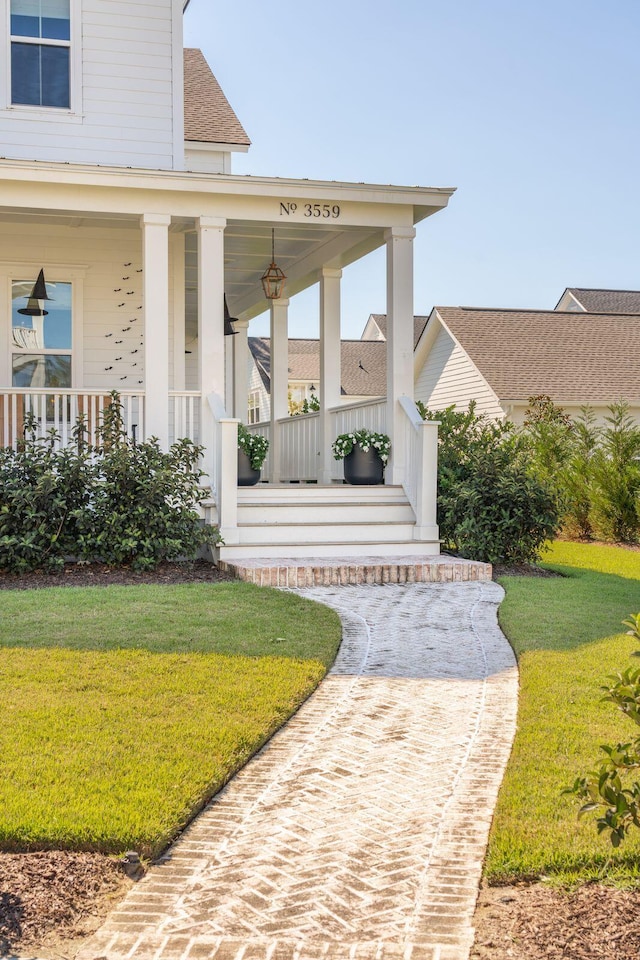 property entrance featuring a porch and a lawn