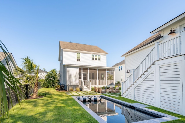 rear view of property featuring a yard and a sunroom