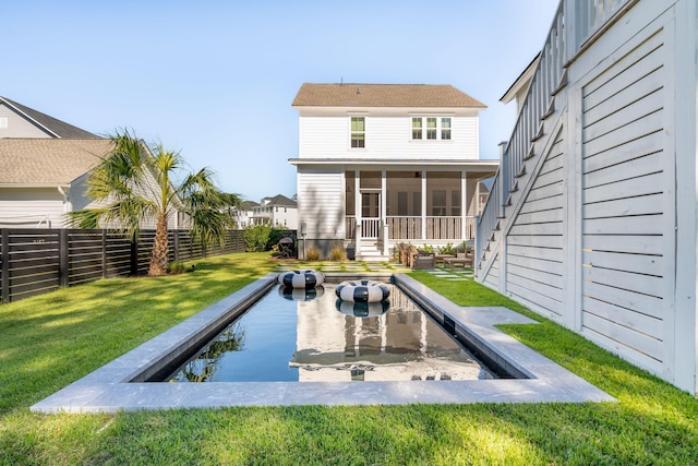 back of house featuring a lawn and a sunroom