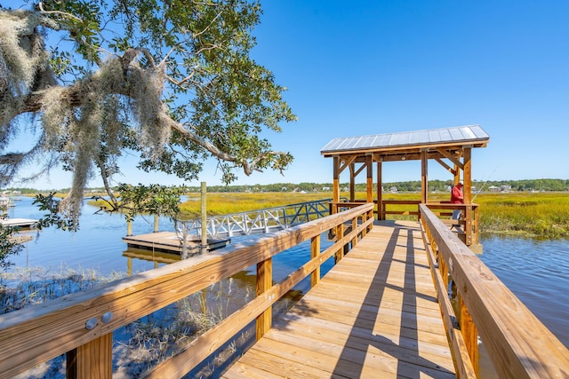 view of dock with a gazebo, a water view, and a rural view