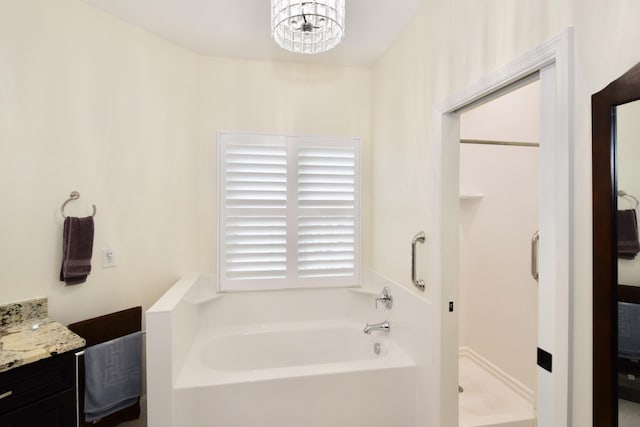 bathroom featuring a tub, a chandelier, and vanity