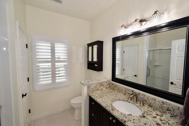 bathroom with toilet, walk in shower, and vanity