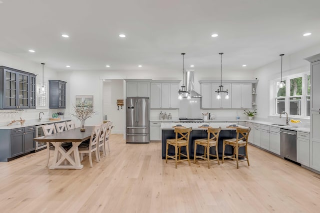 kitchen with stainless steel appliances, a kitchen island, and decorative light fixtures