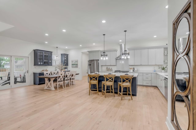 kitchen with pendant lighting, high end refrigerator, a kitchen breakfast bar, and a kitchen island