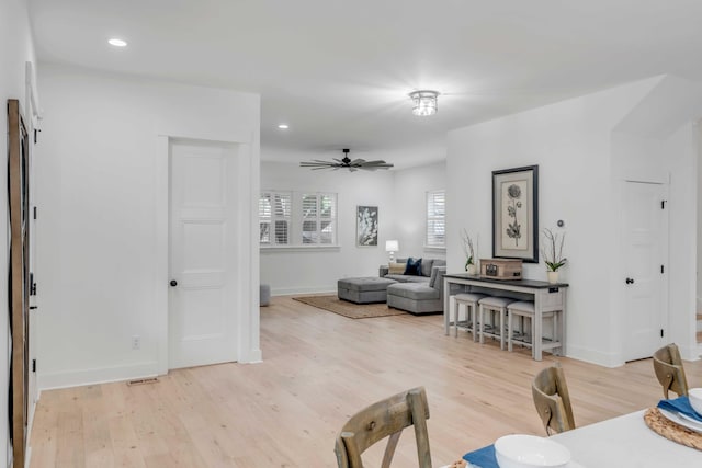 living room featuring ceiling fan and light wood-type flooring