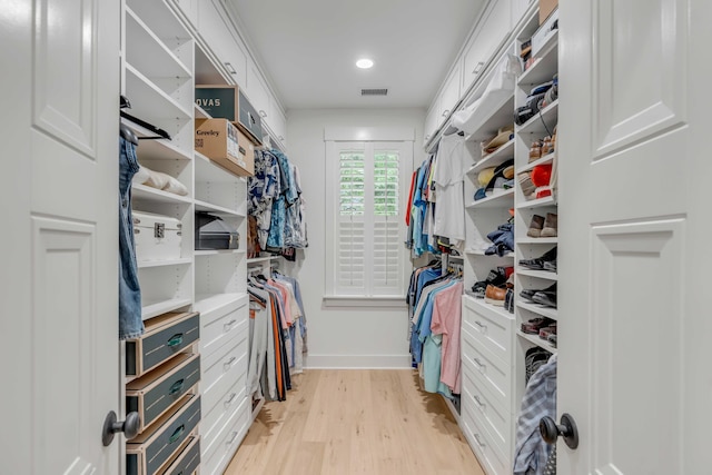 walk in closet with light hardwood / wood-style floors