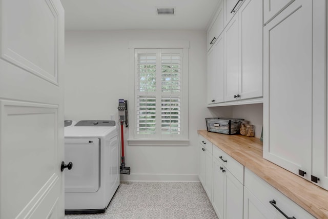 washroom with cabinets, light tile patterned floors, and independent washer and dryer