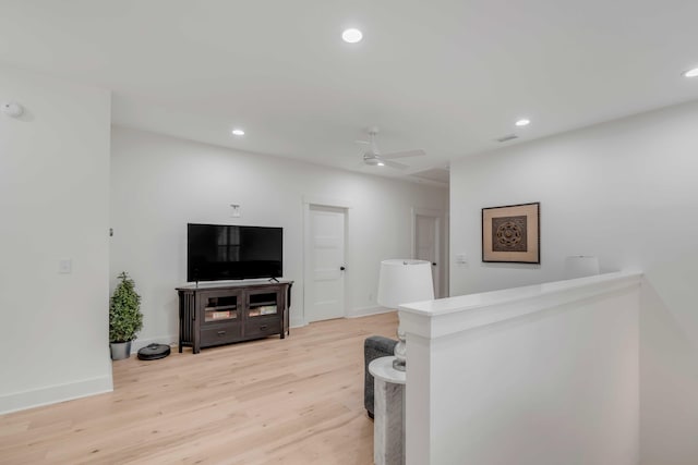 living room with ceiling fan and light hardwood / wood-style floors