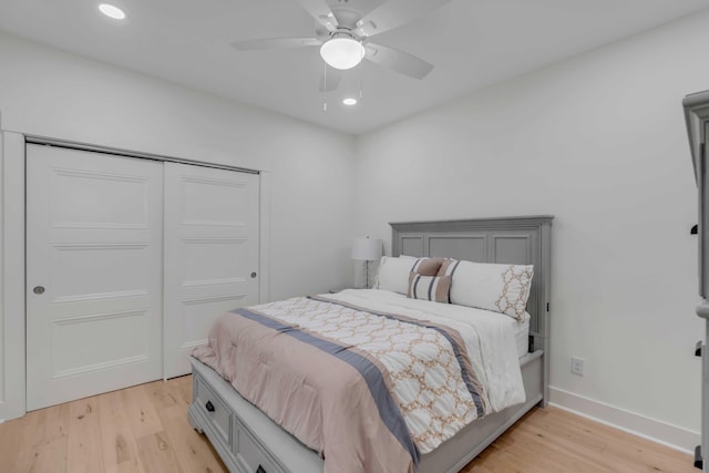 bedroom featuring ceiling fan, light wood-type flooring, and a closet