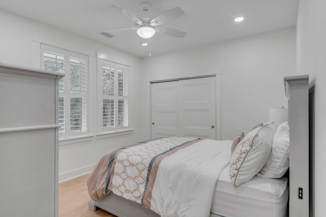 bedroom with a closet, ceiling fan, and light wood-type flooring