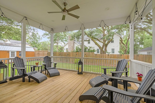 wooden deck featuring an outdoor structure, a yard, and ceiling fan