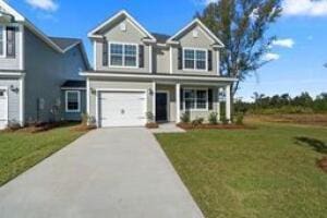 traditional-style home with a garage, a front yard, and aphalt driveway