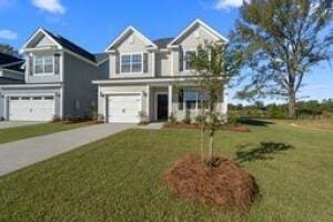 traditional-style house with driveway, an attached garage, and a front yard