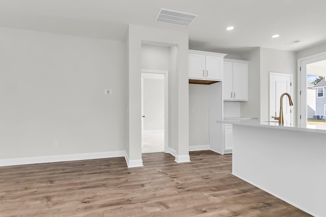 interior space featuring recessed lighting, light wood-style flooring, visible vents, and white cabinetry