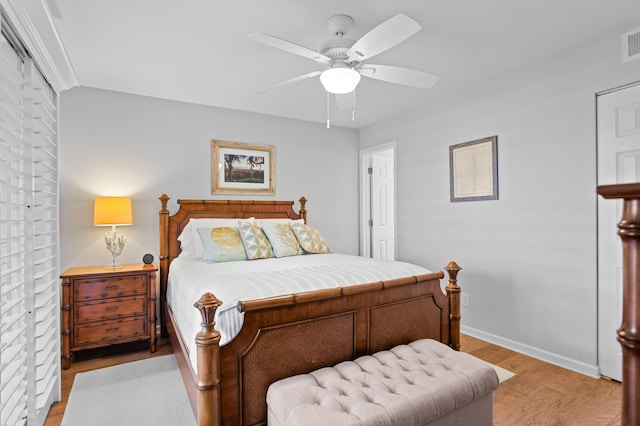 bedroom featuring visible vents, a ceiling fan, light wood-style flooring, and baseboards