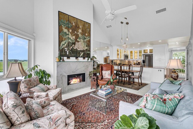 living room with high vaulted ceiling, ceiling fan, and a fireplace