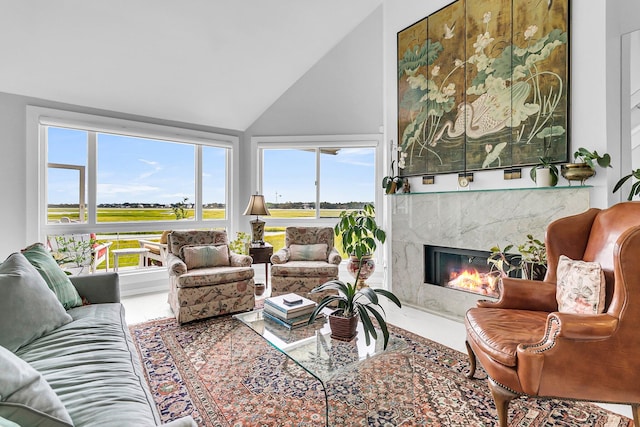 living room with a wealth of natural light, a premium fireplace, and lofted ceiling