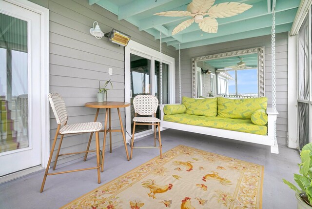 sunroom with ceiling fan and beamed ceiling