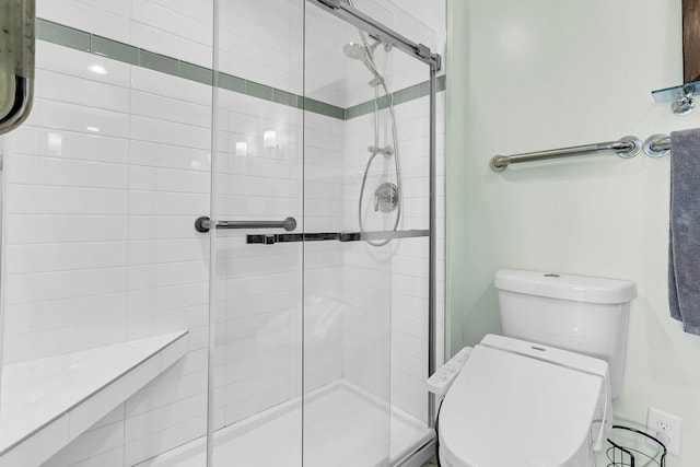 bathroom featuring toilet and a shower with shower door