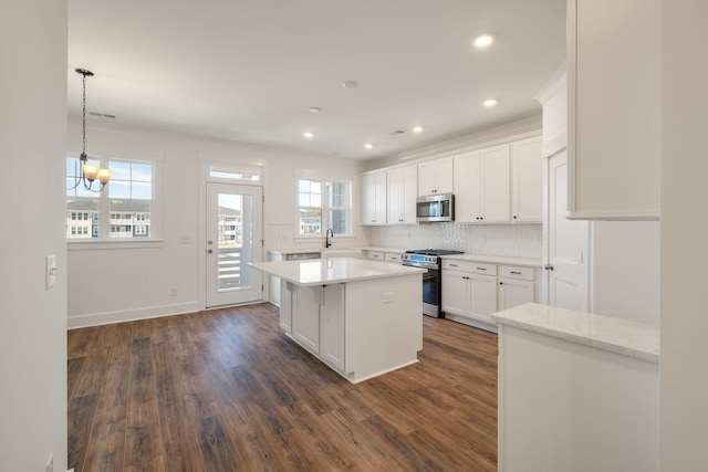 414 Katies Scenic Ct, Charleston, SC 29492 - kitchen with dark wood-style floors, stainless steel appliances, backsplash, a kitchen island, and white cabinetry