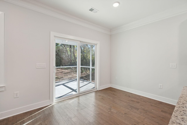 spare room featuring ornamental molding and dark hardwood / wood-style flooring