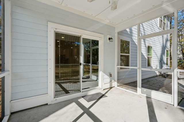 unfurnished sunroom with ceiling fan