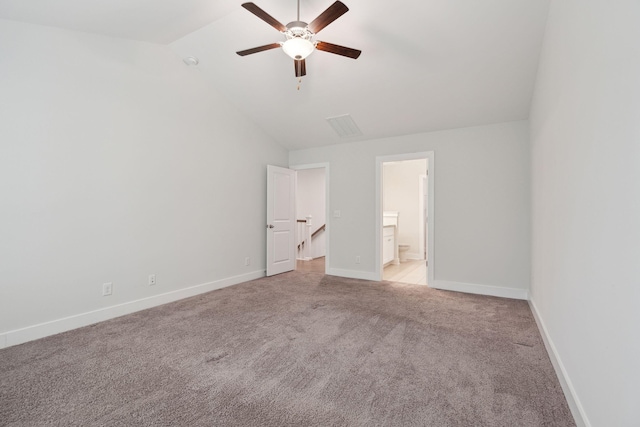 unfurnished bedroom with ensuite bath, vaulted ceiling, light colored carpet, and ceiling fan