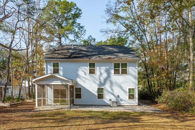 rear view of house featuring a patio, a sunroom, a yard, and central air condition unit