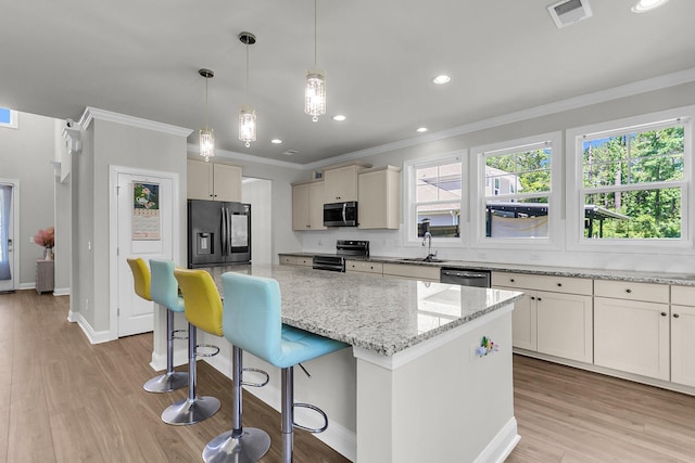 404 Bowstring Dr, Huger, SC 29450 - kitchen with appliances with stainless steel finishes, crown molding, a center island, a breakfast bar area, and light stone countertops