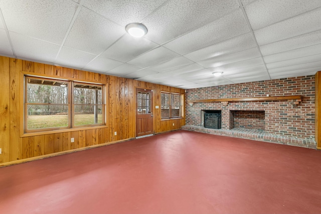 1560 NW Lee Blvd, Orangeburg, SC 29118 - unfurnished living room featuring a fireplace, wood walls, concrete flooring, and a paneled ceiling