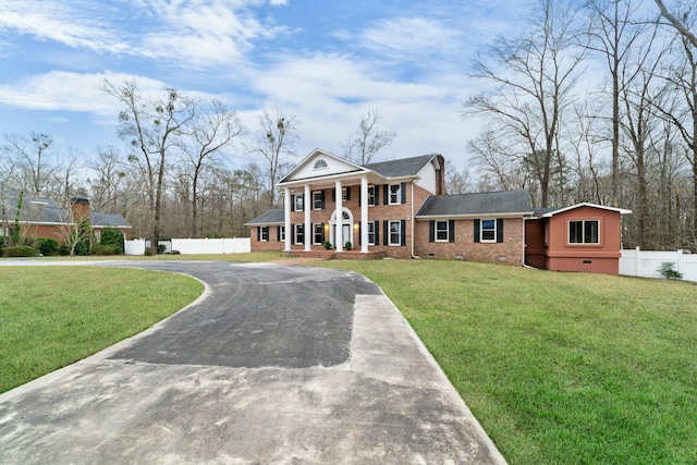 1560 NW Lee Blvd, Orangeburg, SC 29118 - greek revival house with fence, concrete driveway, a front yard, crawl space, and brick siding
