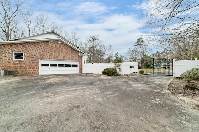 1560 NW Lee Blvd, Orangeburg, SC 29118 - view of property exterior featuring a gate, fence, driveway, central air condition unit, and brick siding