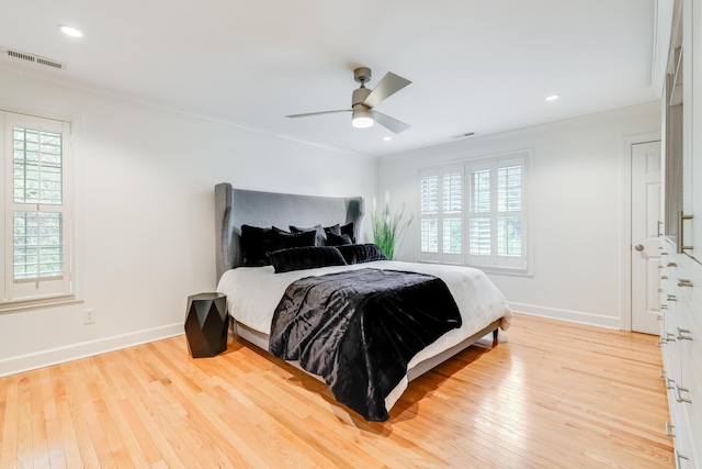 bedroom with light hardwood / wood-style flooring, ceiling fan, and ornamental molding