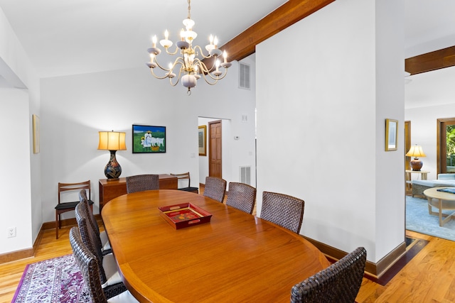 dining area with beam ceiling, high vaulted ceiling, light hardwood / wood-style flooring, and a notable chandelier