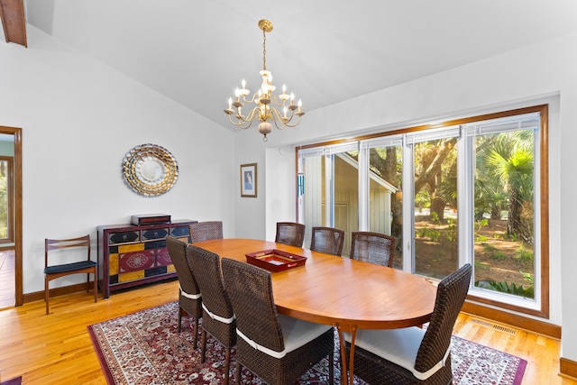 dining space featuring a notable chandelier, light hardwood / wood-style flooring, and vaulted ceiling