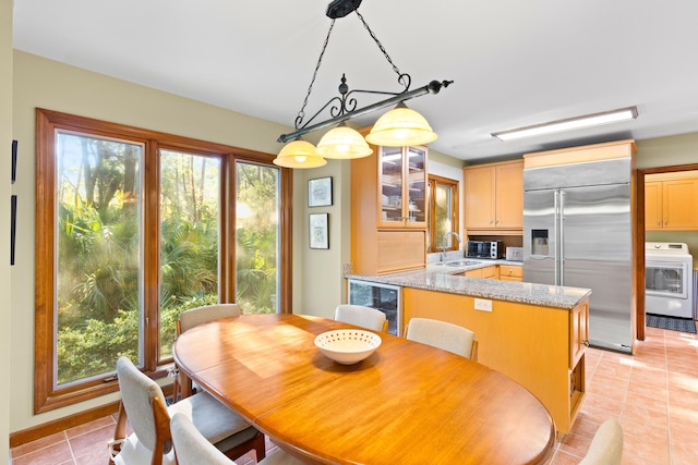 dining area featuring light tile patterned floors, sink, and beverage cooler