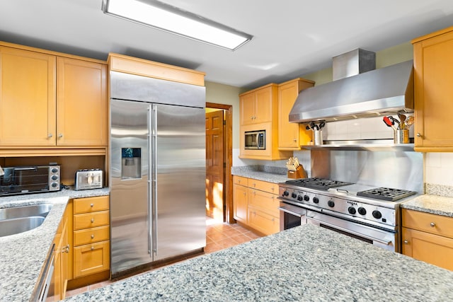 kitchen featuring light stone counters, backsplash, high quality appliances, light tile patterned flooring, and exhaust hood