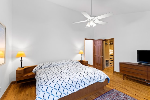 bedroom with ceiling fan, wood-type flooring, and high vaulted ceiling