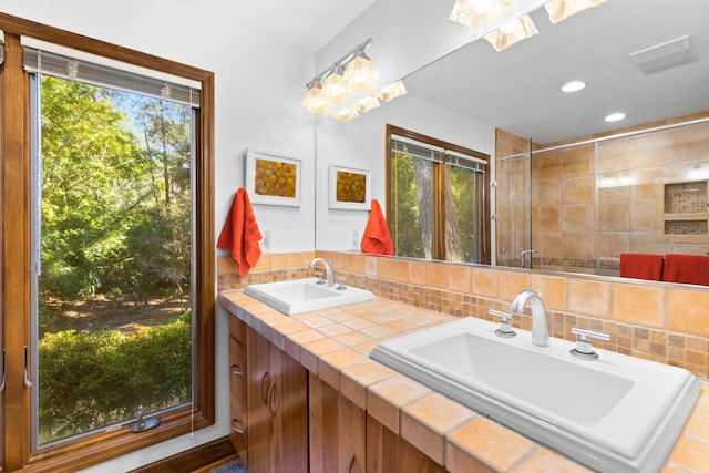 bathroom with vanity, tasteful backsplash, and an enclosed shower