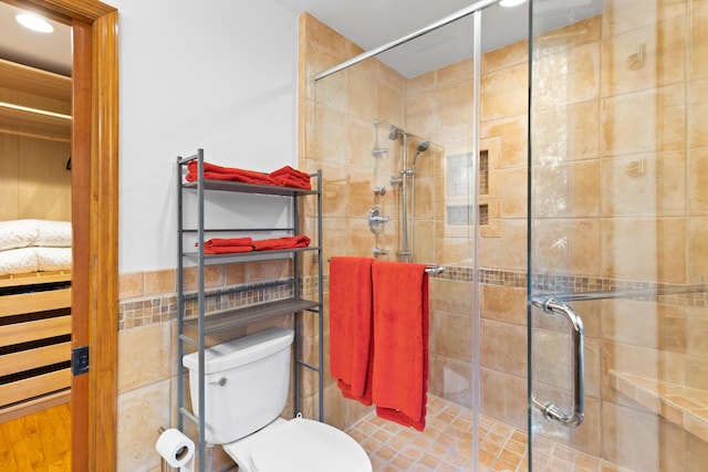 bathroom with toilet and a shower with shower door