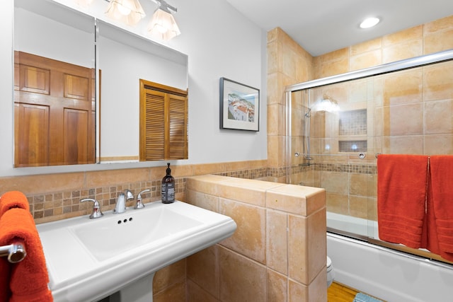 full bathroom with shower / bath combination with glass door, sink, and toilet