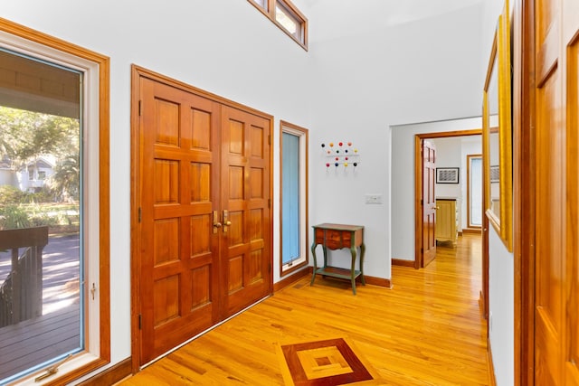 foyer entrance featuring a towering ceiling and light hardwood / wood-style floors