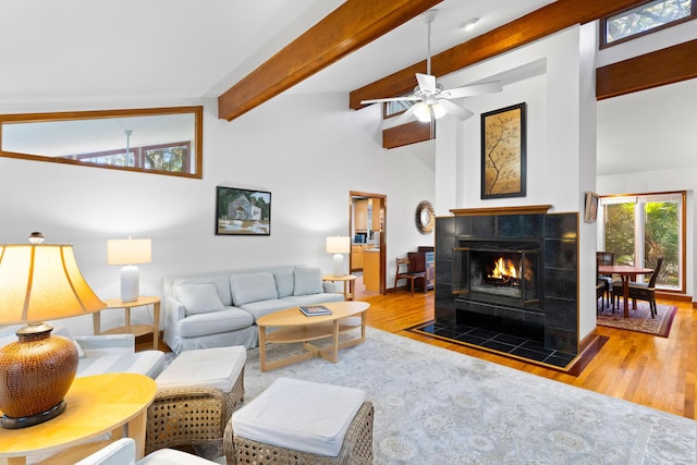 living room featuring ceiling fan, hardwood / wood-style floors, beamed ceiling, and high vaulted ceiling