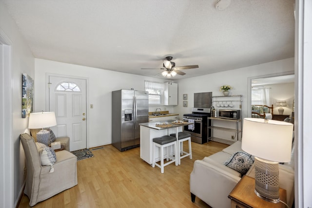 647 Ellis St, Mount Pleasant, SC 29464 - kitchen with appliances with stainless steel finishes, a sink, light wood-type flooring, a kitchen island, and a ceiling fan