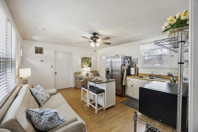 647 Ellis St, Mount Pleasant, SC 29464 - kitchen with a sink, stainless steel fridge, a ceiling fan, a textured ceiling, and a breakfast bar area